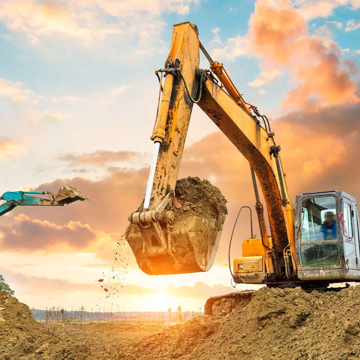 Excavator digging in the ground in preparation to lay foundation