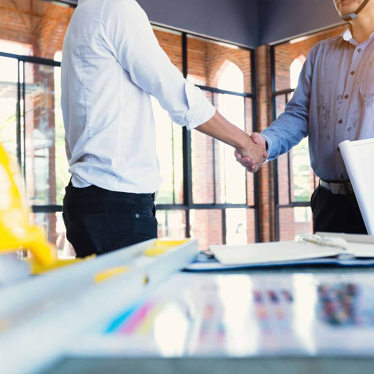 A contractor and client shaking hands