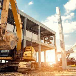 Machinery In Front of Cement Building Frame