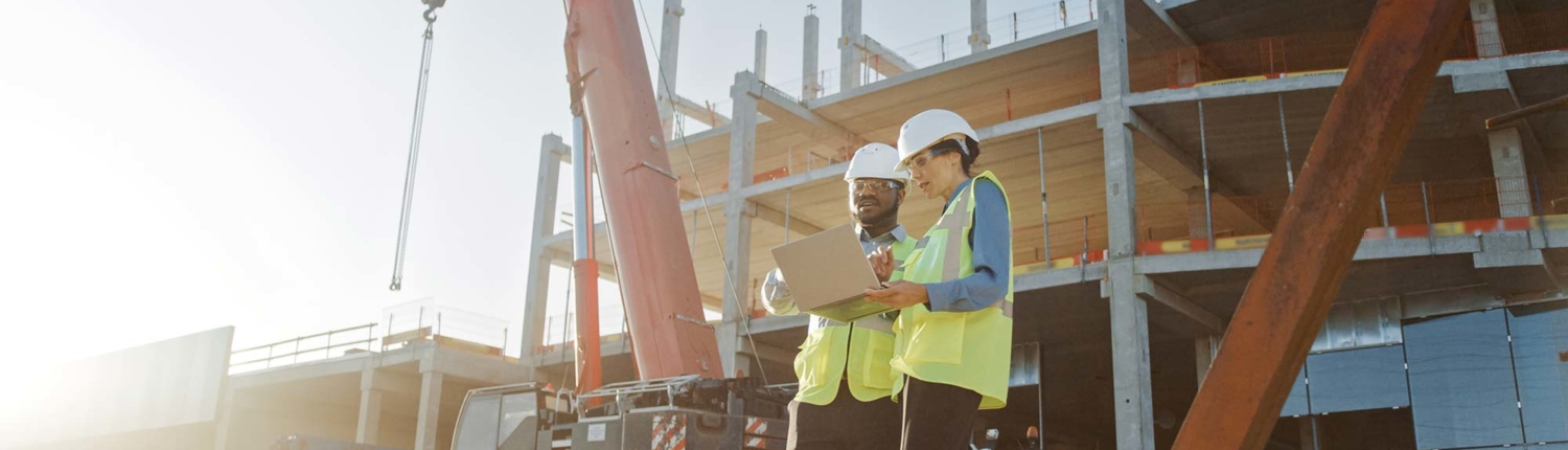 Construction workers looking over construction plans during new construction