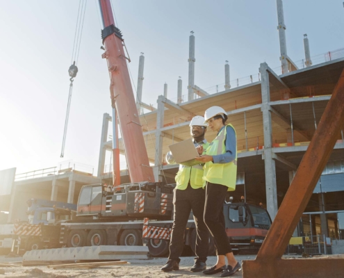 Construction workers looking over construction plans during new construction