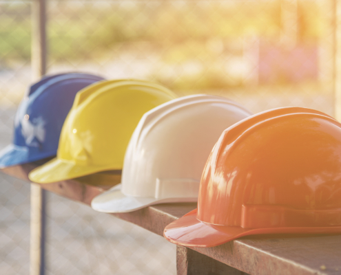 Hard-hats lined up on a bench