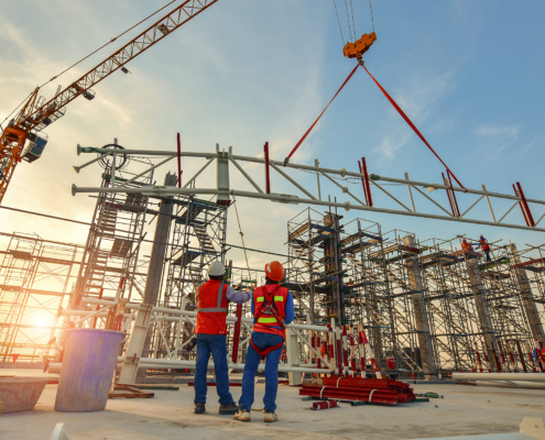 Workers watching a metal building construction process take place