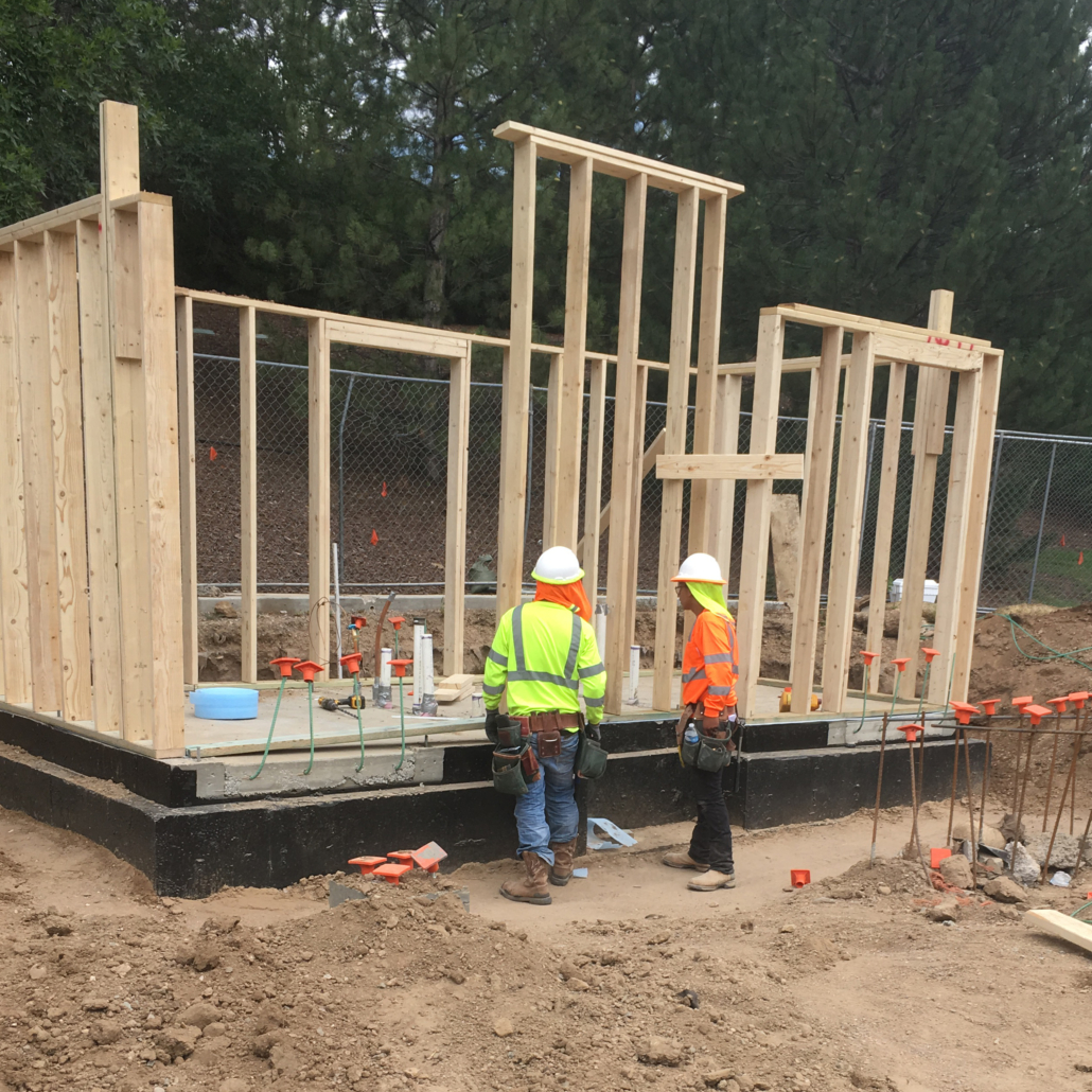 Construction workers standing in front of a building frame