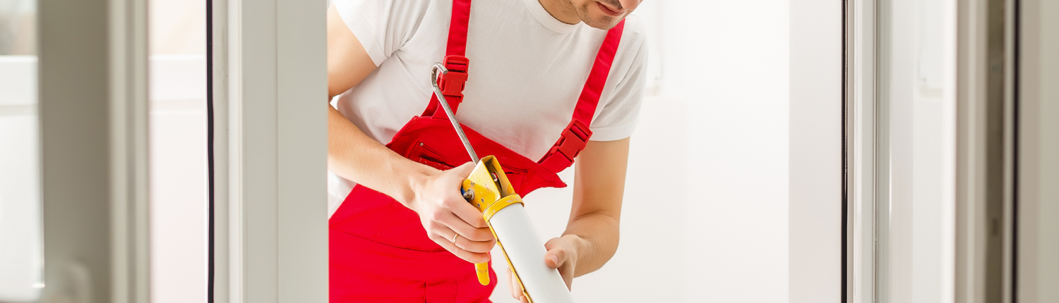 Construction worker applying caulk as part of a tenant finish project