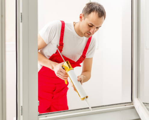 Construction worker applying caulk as part of a tenant finish project