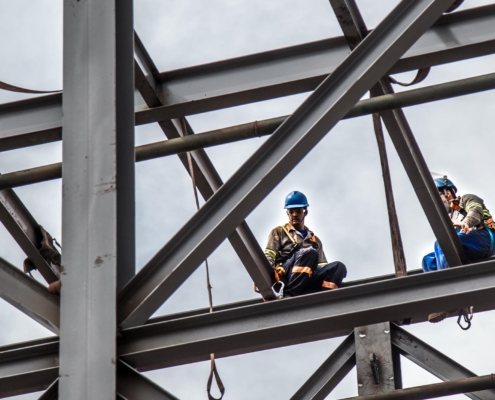 Image of two workers on top of a steel construction beam