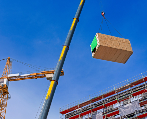 Crane lifting a prefabricated wooden building module