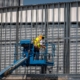 Worker on lift infront of metal constructed structure