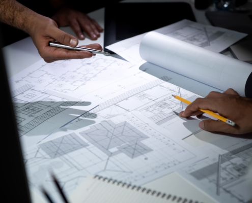 Architect team discussing blueprint paper in office
