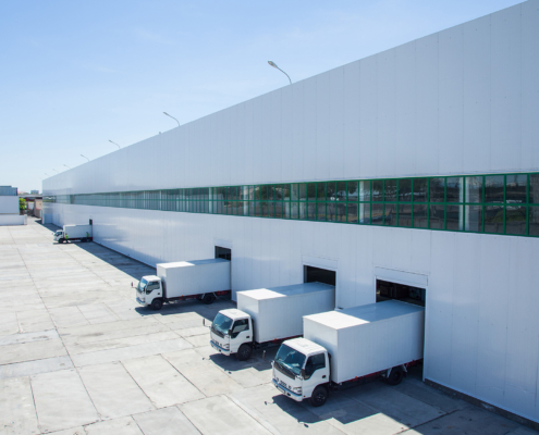 facade of an industrial building and warehouse with freight cars in length